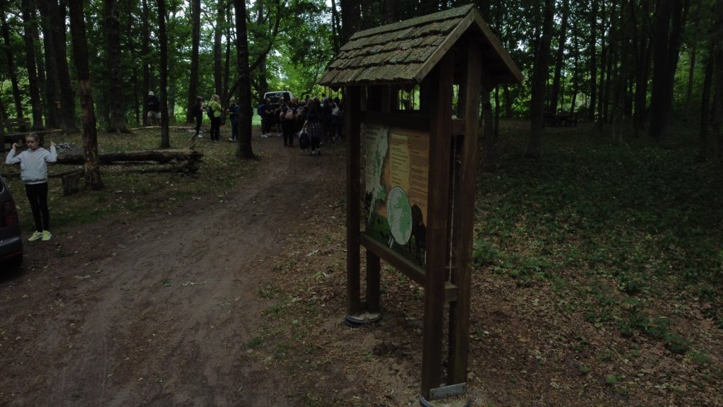 Dalyviai prie pažintinio tako informacijos stendo