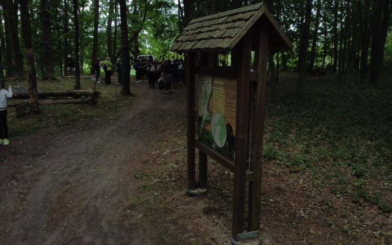 Dalyviai prie pažintinio tako informacijos stendo